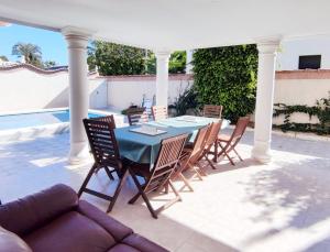 a patio with a table and chairs and a couch at Villa SunShine Ciudad Quesada Spain in Ciudad Quesada