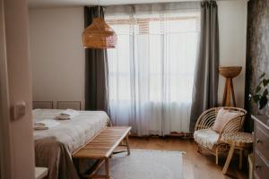 a bedroom with a bed and a chair and a window at Simply rooms in Slavkov u Brna