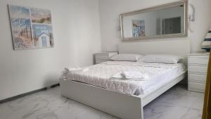 a white bedroom with a bed and a mirror at Medusa Felix in Cullera