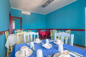 a blue dining room with a table and chairs at Al ViaVai in San Cosmo Albanese