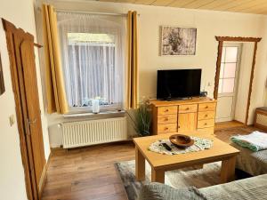 a living room with a tv and a table at Ferienwohnung Neubert in Leutenberg