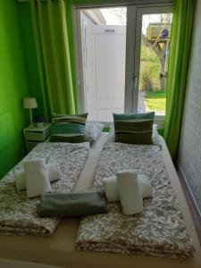 2 Betten in einem grünen Zimmer mit Fenster in der Unterkunft Vakantiewoning voor het gezin in Stavenisse in Stavenisse + 37 Fotos