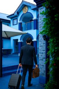 a man in a suit pulling a suitcase at Luxurious Lukes Apartment in Benin City
