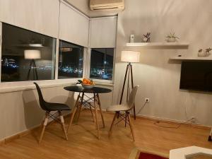 a living room with a table and chairs and a television at Faros in Chios