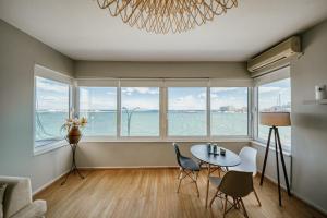 a living room with a table and chairs and windows at Faros in Chios +5 photos