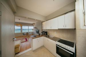 a kitchen with white cabinets and a view of the ocean at Faros in Chios