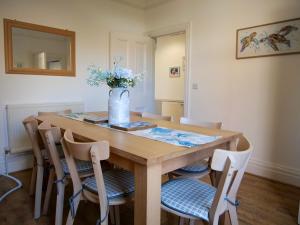 a dining room table with chairs and a vase of flowers at Seashells in Bridlington