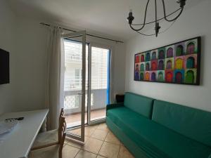 a living room with a green couch and a window at Residence Ambra in Lido di Jesolo