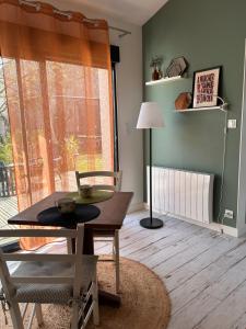 a living room with a table and chairs and a window at Le Bulloire in Montlouis-sur-Loire