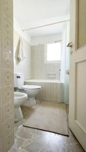 a bathroom with a toilet and a sink and a tub at Beachfront Family Villa in Eretria