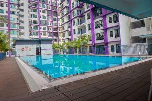 a swimming pool in front of some buildings at Walid Guesthouse, cozy hill view in Ayer Keroh