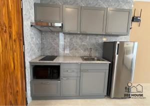 una cocina con fregadero y refrigerador en 202 HOUSE near Bangtao Muay Thai & MMA, en Ban Thalat Choeng Thale 5 fotos más