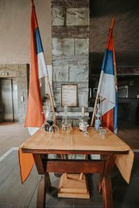 兹德罗Hotel Mlavske Terme Ždrelo的一张木桌,上面有两面旗帜