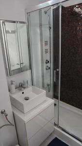 a white bathroom with a sink and a shower at LUXURY studio PLAZA M DRUMUL TABEREI in Bucharest +23 photos