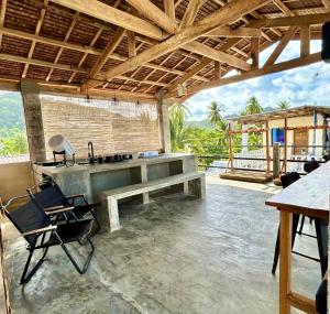 a large outdoor kitchen with a bench and a sink at Katre Pacifico, Siargao - SELF CHECK-IN Budget Hostel in Pacifico, Siargao in San Isidro