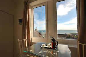 a table with a coffee maker on it next to a window at Ard na Mara- Coastal Apartment in Pittenweem