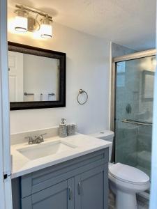 Un baño con lavabo, inodoro y espejo. en Grand Superior 3BR Condo Apartment Near Disney Parks, en Kissimmee