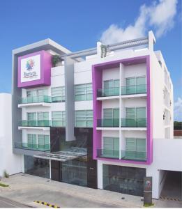 a pink and white building with a sign on it at Hotel Baroca in Montería