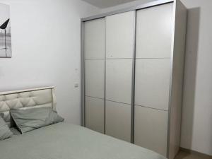 a bedroom with a large white cabinet next to a bed at פנינת הדגן 32 in El ‘Affūle