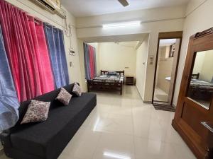 a living room with a couch and a bedroom at Ritu Heritage Homestay in Trivandrum