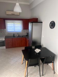 a black table and chairs in a kitchen with a refrigerator at Ellegant apartment in Politika in Politika +17 photos