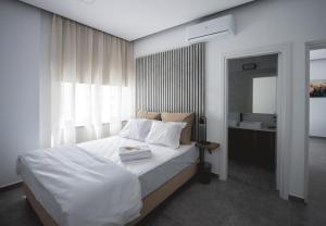 a bedroom with a white bed and a bathroom at Le Bouquet Luxury Suites Ltd in Nicosia