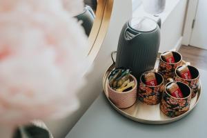 a table with a coffee maker and cups on a plate at RST Bramley Boutique in Liverpool