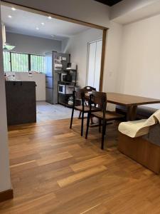 a living room with a wooden table and chairs at GREEN ViLLA南大阪 in Mikkaichi
