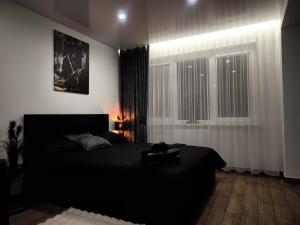 a bedroom with a black bed and a window at DOMINO apartamentai, SELF CHECK-IN in Panevėžys +35 photos