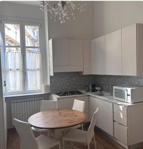 a kitchen with a wooden table and white cabinets at Wonderful Central apartment in Porta Garibaldi,Moscova in Milan