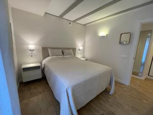 a bedroom with a large white bed with two tables at Villmor - B23 - Corazón del Casco in Benasque