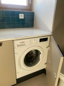 a washer and dryer under a counter in a kitchen at Gîte lumineux avec jardin, vue sur Peyrepertuse in Rouffiac-des-Corbières
