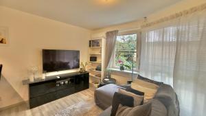 ein Wohnzimmer mit Sofa und Flachbildfernseher in der Unterkunft Exclusive Apartments Stuttgart - Gablenberg in Stuttgart + 2 Fotos