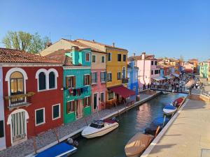 a view of a canal with colorful buildings and boats at Tiffany Home in Burano