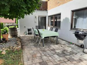 eine Terrasse mit einem Tisch, Stühlen und einem Grill in der Unterkunft Dörrs vacation home with pool and garden in Weißbach
