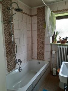 ein Badezimmer mit Badewanne und Waschbecken in der Unterkunft Dörrs vacation home with pool and garden in Weißbach + 12 Fotos