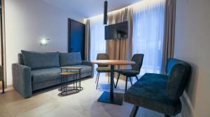 a living room with a couch and a table and chairs at NordOst fineliving in Ischgl
