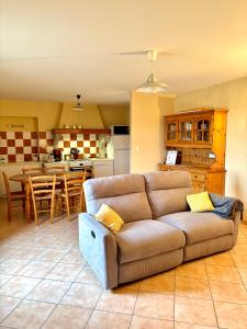 a living room with a couch and a kitchen at Gîte lePigeonnier - Ardèche in Aubignas