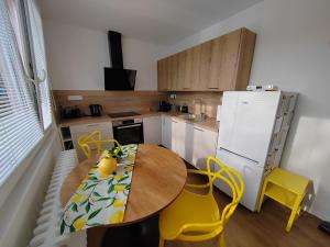 a kitchen with a wooden table and yellow chairs at BestNest HK in Hradec Králové