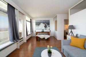 a living room with a couch and a table at Leuchtturm-Loft mit Meerblick in Sierksdorf +21 photos