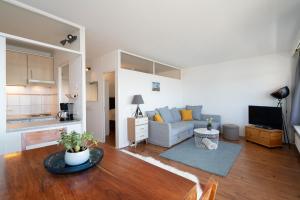a living room with a couch and a table at Leuchtturm-Loft mit Meerblick in Sierksdorf