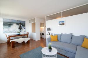 a living room with a couch and a table at Leuchtturm-Loft mit Meerblick in Sierksdorf