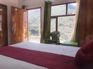 a bedroom with a bed and a large window at Parvatiya Homestay in Mussoorie