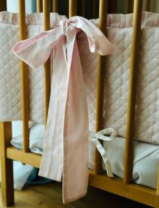 加茨比亚格拉Niebieski Domek - Gościmy tylko Dzieci z Rodzicami - u nas dzieci to VIPy!的一张带粉色和白色床单及枕头的婴儿床