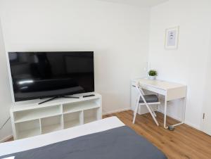 a living room with a tv and a desk at Apartment del Mardy in Ostfildern
