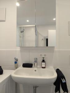 a white bathroom with a sink and a mirror at Apartment del Mardy in Ostfildern +13 photos
