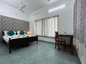 a bedroom with a bed and a desk and a table at Coramandal Heritage in Puducherry +82 photos