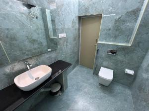 a bathroom with a sink and a toilet at Coramandal Heritage in Puducherry