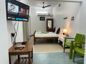 a room with a bed and a flat screen tv at Coramandal Heritage in Puducherry