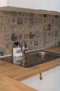 een roestvrijstalen wastafel in een keuken met tegels bij Lemon House - 400m from the Beach - Wifi in Albufeira +31 foto's